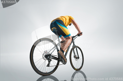 Image of The bicyclist on gray, studio shot.