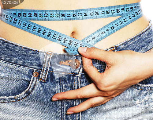 Image of girls stomach measuring with tape twice isolated close up