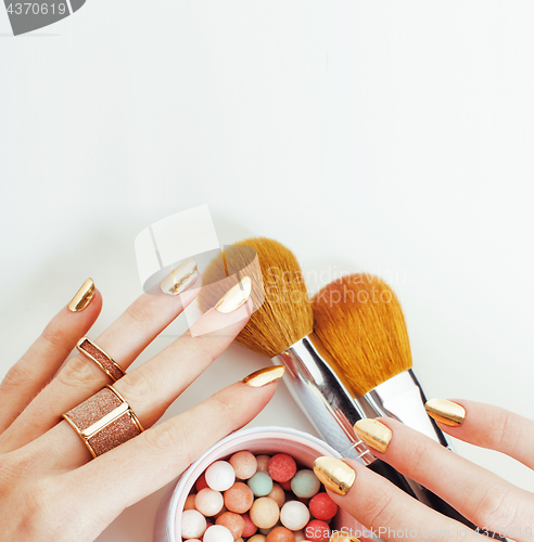 Image of woman hands with golden manicure  many rings holding brushes, make up artist stuff stylish and pure