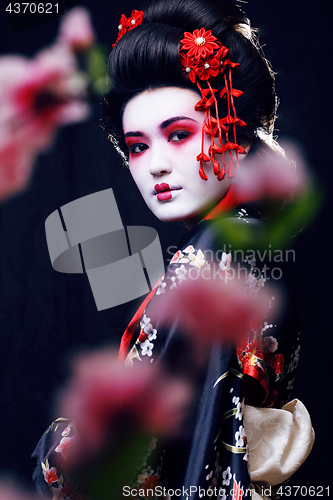 Image of young pretty real geisha in kimono with sakura and decoration, oriental style fashion