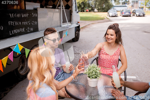 Image of friends clinking bottles with drinks at food truck