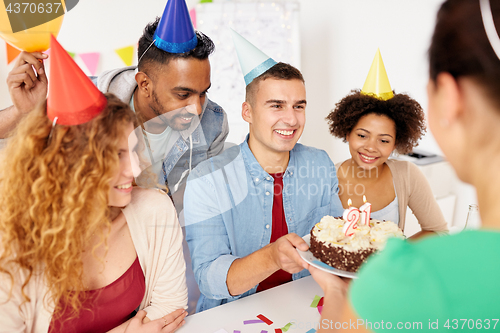 Image of team greeting colleague at office birthday party