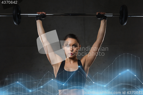 Image of young woman flexing muscles with barbell in gym