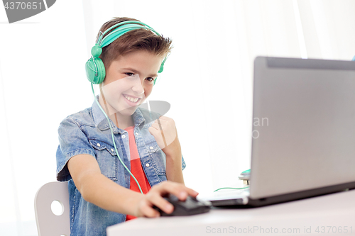 Image of boy in headphones playing video game on laptop