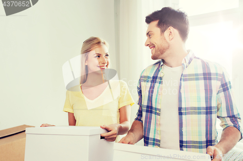 Image of smiling couple with big boxes moving to new home