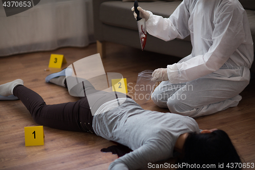 Image of criminalist collecting crime scene evidence
