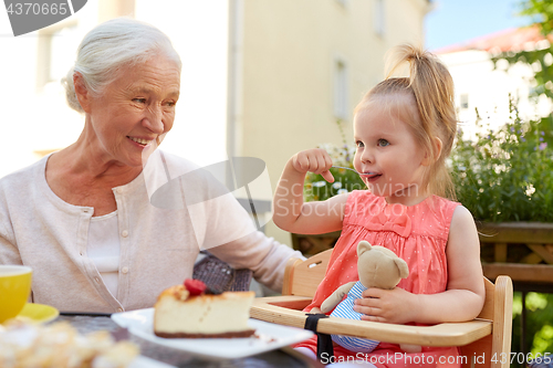 Image of little girl with grandmother eating cafe