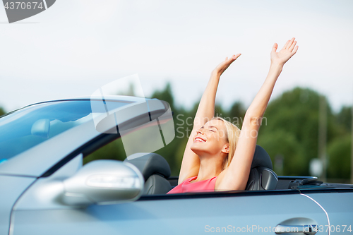 Image of happy young woman in convertible car