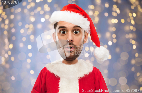 Image of man in santa claus costume over christmas lights