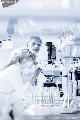 Image of Health care researchers microscoping in scientific laboratory.