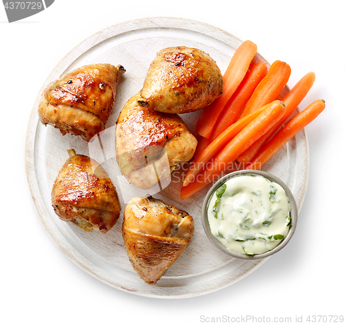 Image of grilled chicken legs on wooden cutting board
