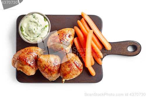 Image of roasted chicken legs on wooden cutting board