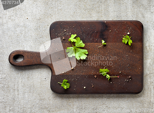 Image of Parsley and pepper on wooden cutting board