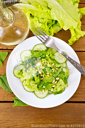 Image of Salad from spinach and cucumber with napkin on board top