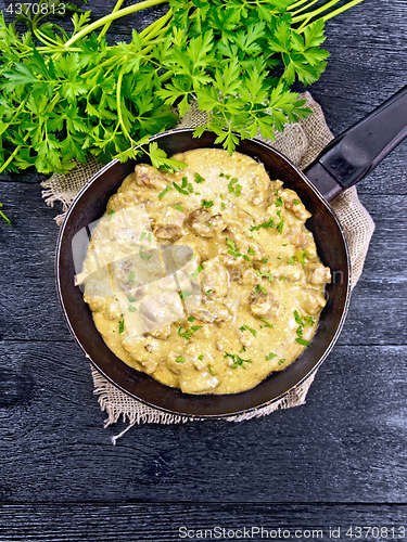 Image of Meat stewed with cream in pan on black board top