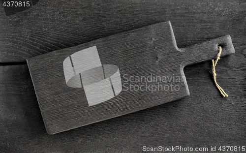 Image of black cutting board on wooden table