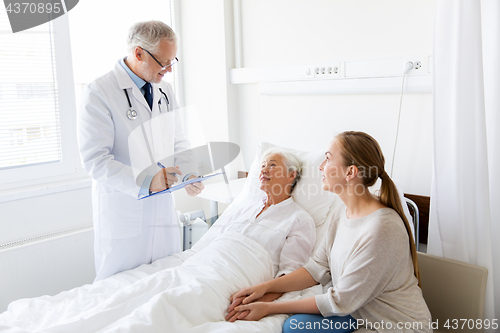 Image of senior woman and doctor with clipboard at hospital