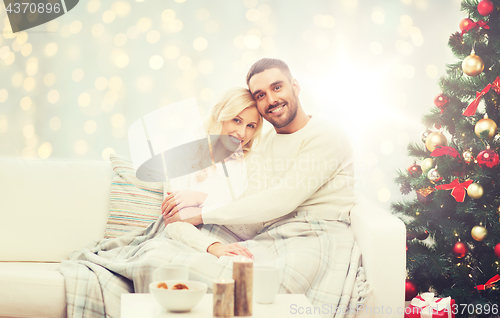 Image of happy couple hugging over christmas tree