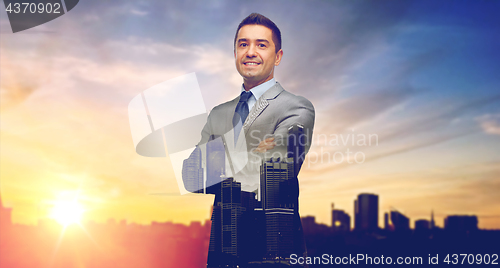 Image of happy smiling businessman over city background