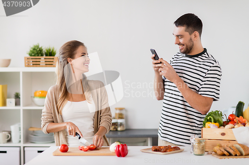 Image of happy couple cooking food at home kitchen