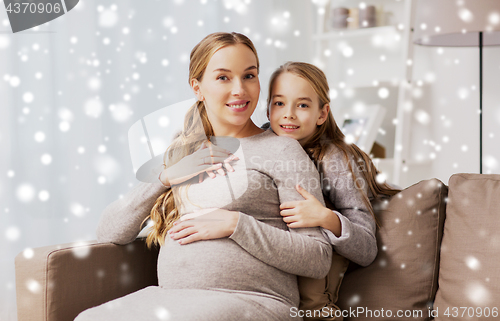 Image of happy pregnant woman and girl hugging at home