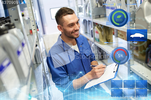 Image of smiling auto mechanic with clipboard at car shop