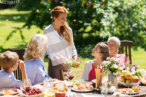 Image of happy family having dinner or summer garden party