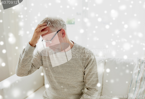 Image of senior man suffering from headache at home