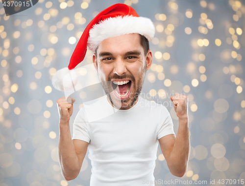 Image of screaming man in santa hat over lights