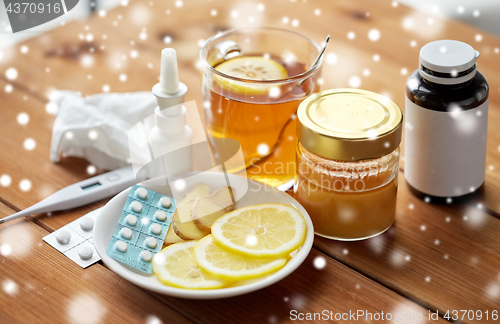 Image of drugs, thermometer, honey and cup of tea on wood