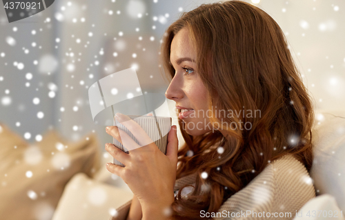 Image of happy woman with cup of coffee in bed at home