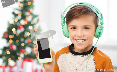 Image of boy with smartphone and headphones at christmas