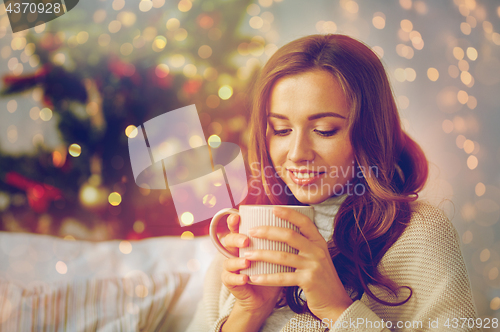 Image of happy woman with cup of tea at home for christmas