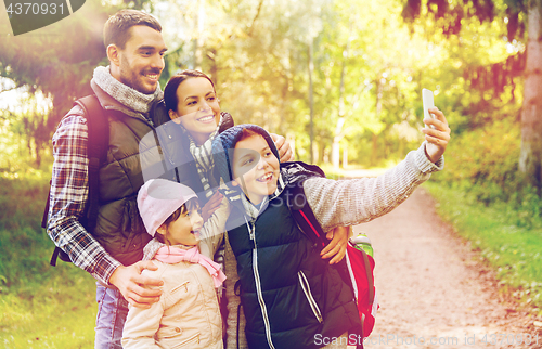 Image of family with backpacks taking selfie by smartphone
