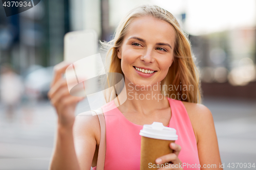 Image of woman with coffee taking selfie by smartphone