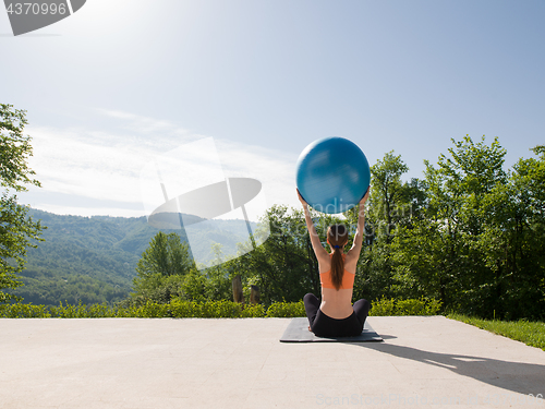 Image of woman doing exercise with pilates ball