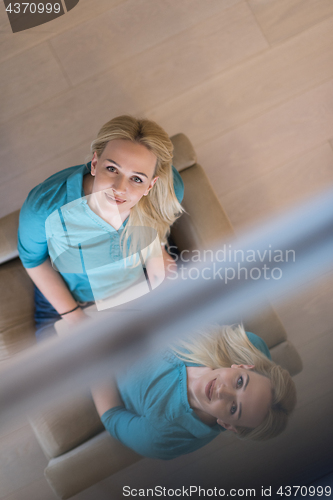 Image of Young woman using laptop at home top view
