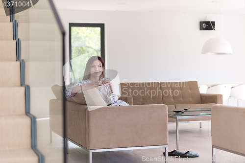 Image of young woman in a bathrobe enjoying morning coffee