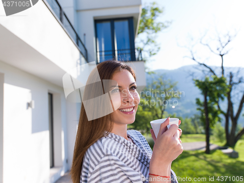 Image of woman in a bathrobe enjoying morning coffee