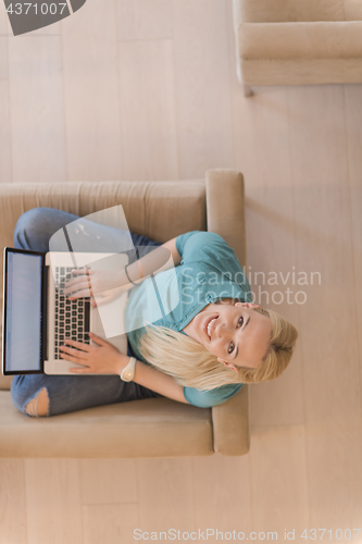 Image of Young woman using laptop at home top view