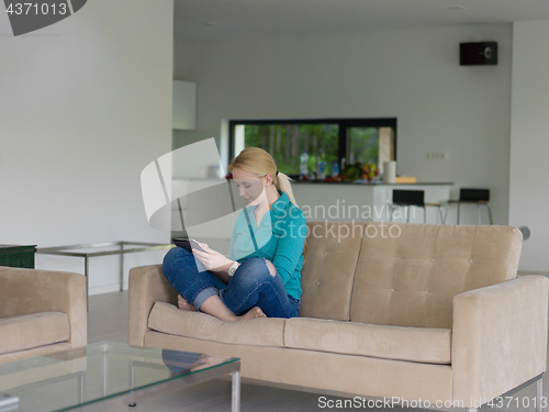 Image of woman on sofa using tablet computer