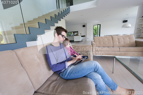 Image of mother and her cute little daughter are using a tablet