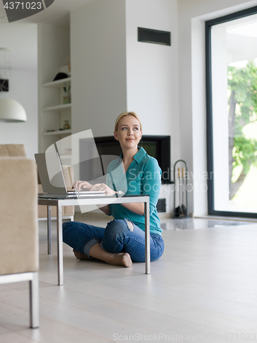 Image of young women using laptop computer on the floor