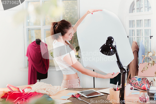 Image of Fashion designers working in studio sitting on the desk