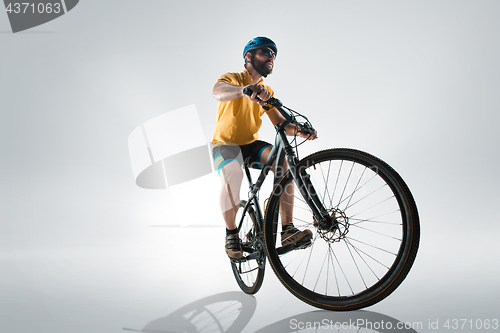 Image of The bicyclist on gray, studio shot.