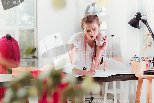 Image of Fashion designers working in studio sitting on the desk