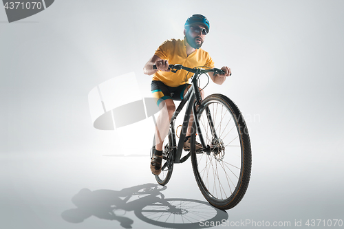 Image of The bicyclist on gray, studio shot.