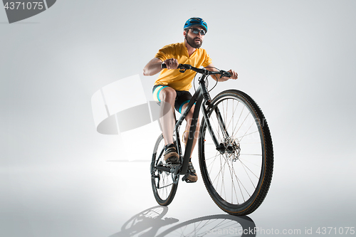 Image of The bicyclist on gray, studio shot.