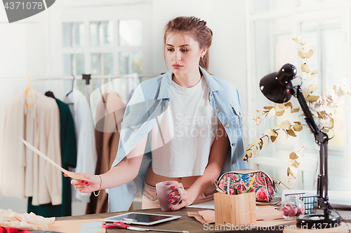 Image of Fashion designers working in studio sitting on the desk