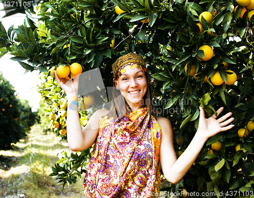 Image of pretty woman in orange grove smiling